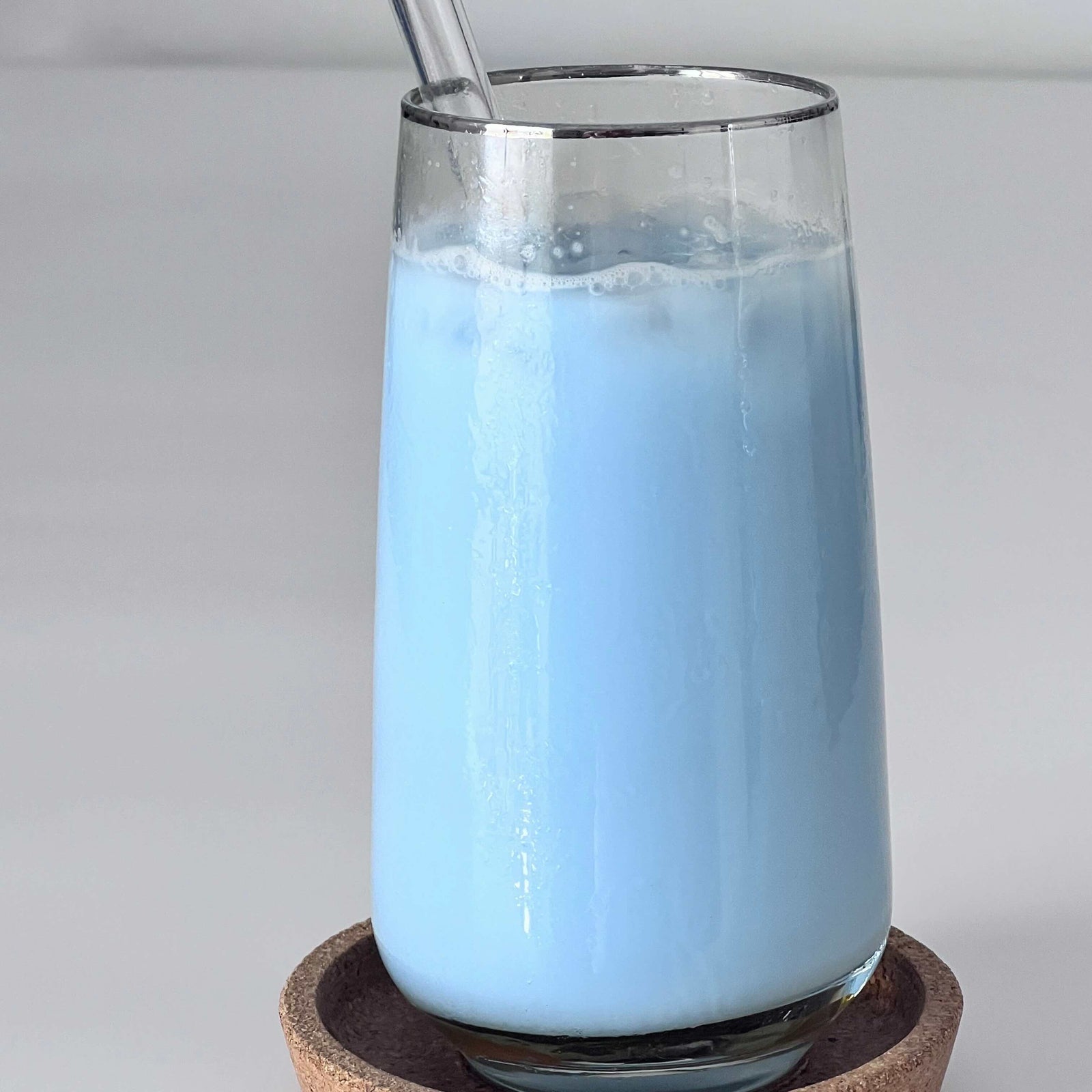 Coconut milk drink colored with blue spirulina – soft pastel blue beverage in glass