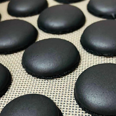 Macaron shells colored with activated charcoal – smooth natural black macarons ready for filling